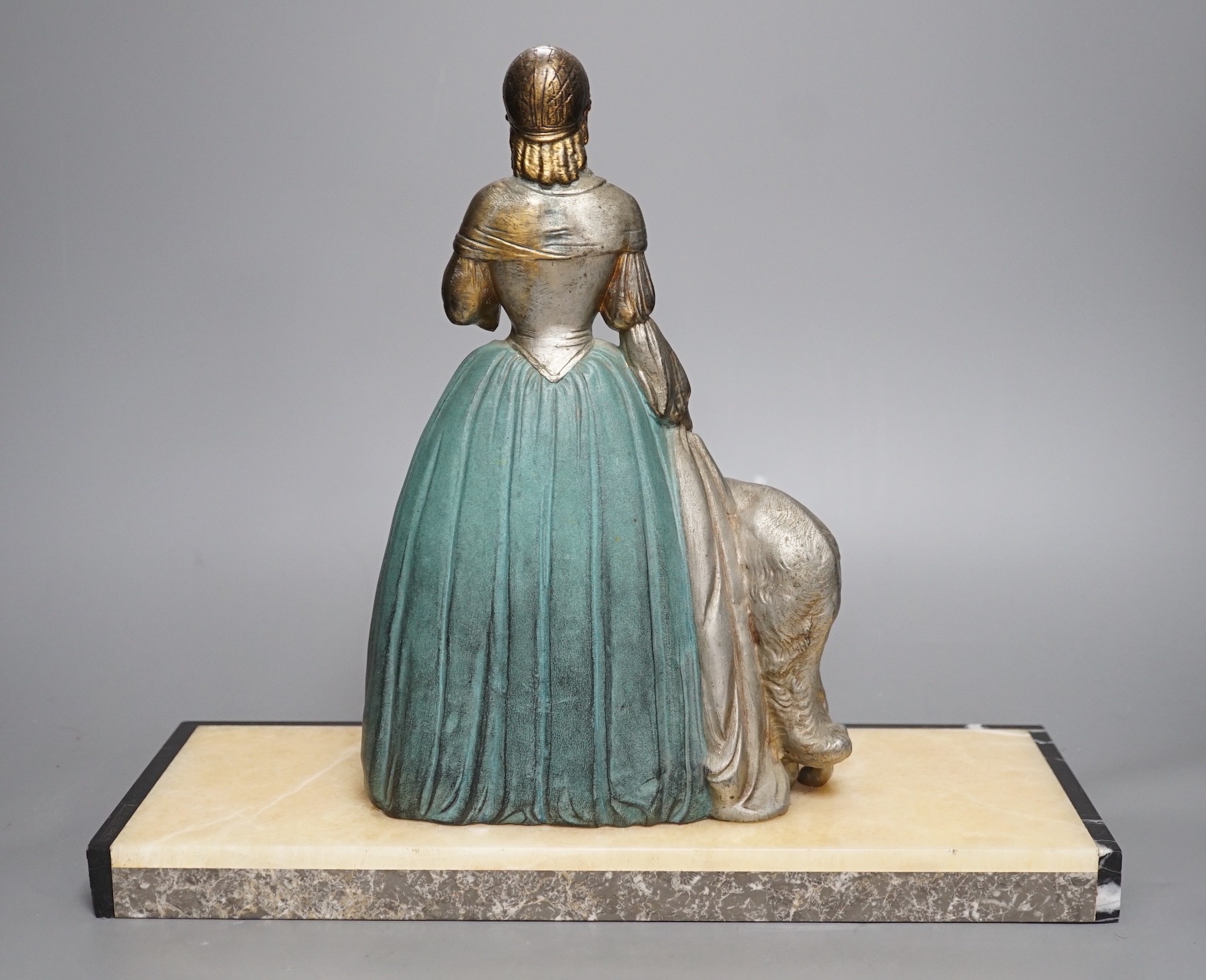 An Art Deco cold painted spelter and composition figure of a lady with a dog, signed R Miandres, 38cm wide